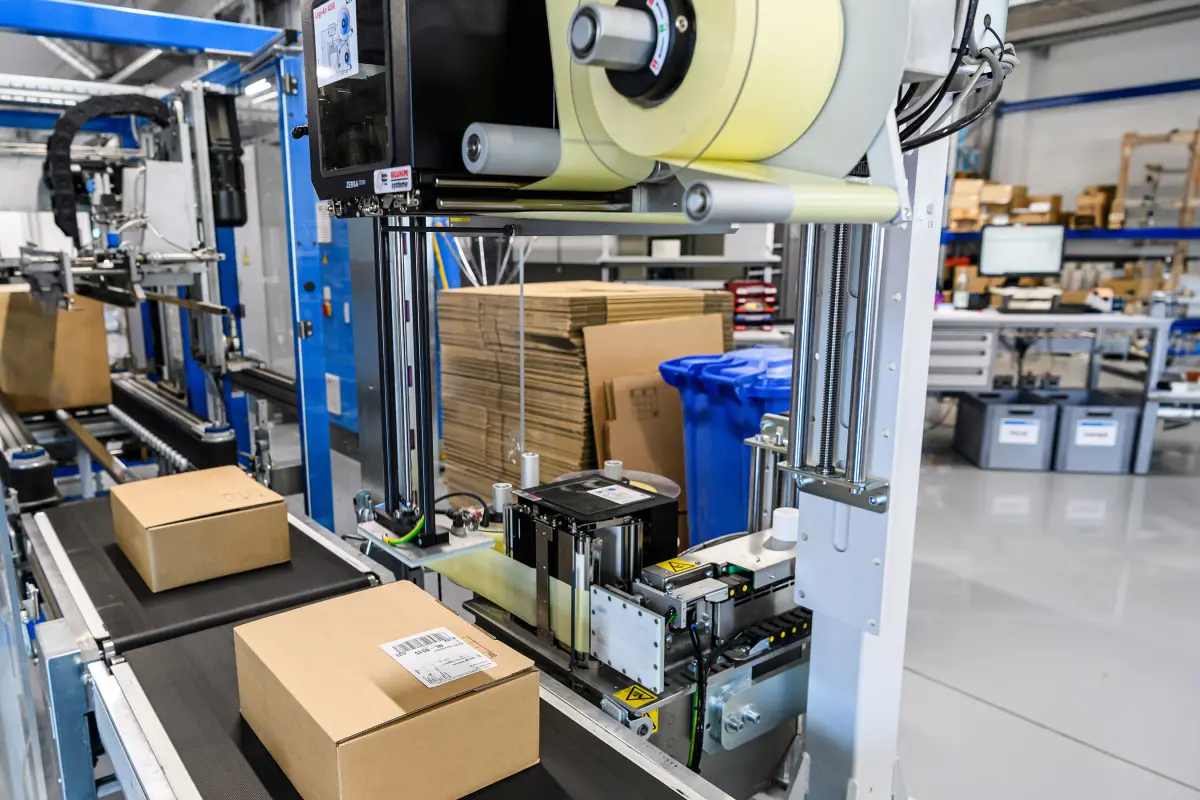 Versandetiketten werden an Logistiklinie appliziert